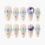 Handmade press-on nails with nude base, blue and crystal rhinestone accents, large purple gems