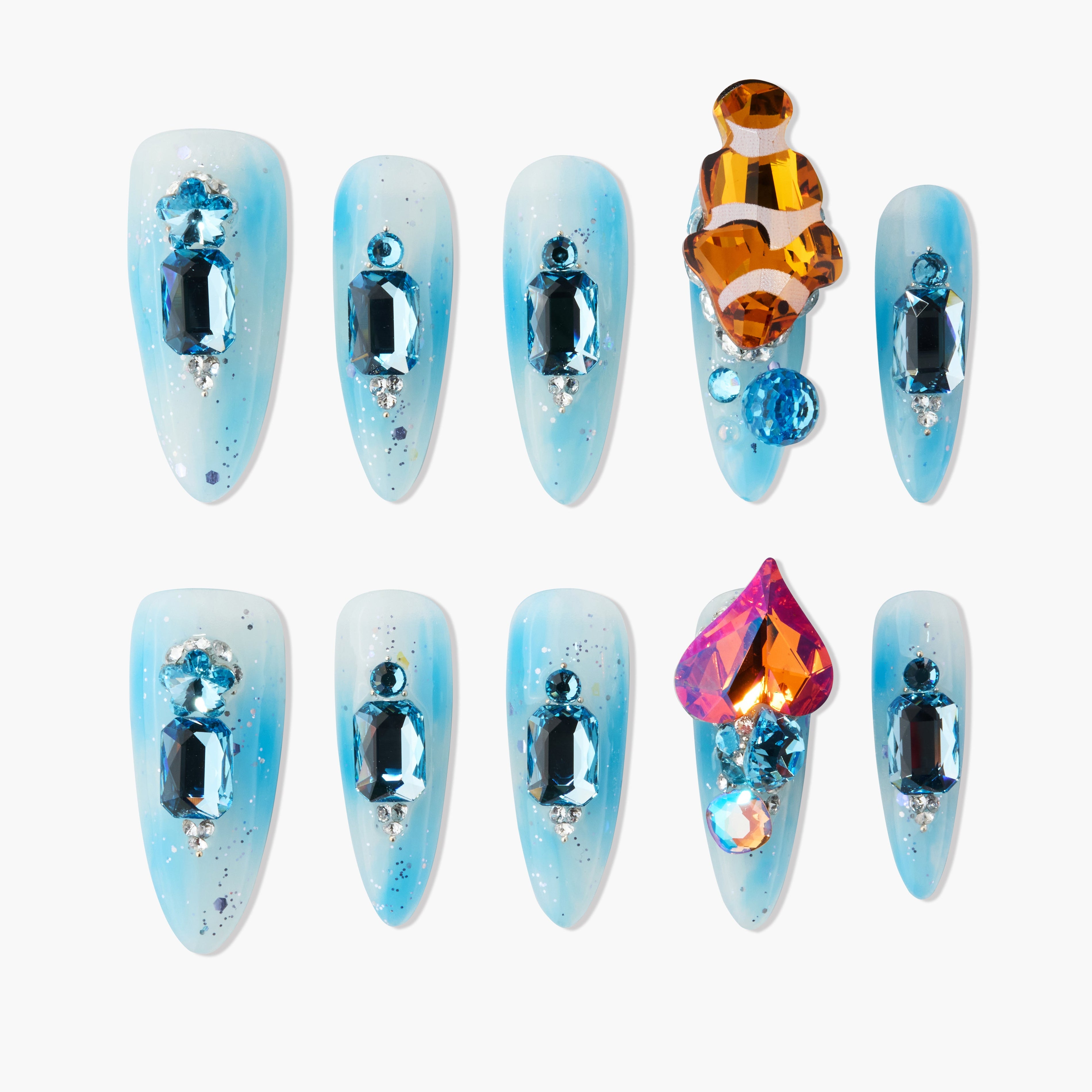Handmade blue press-on nails with large colorful gemstones and silver glitter accents, arranged on a white background.