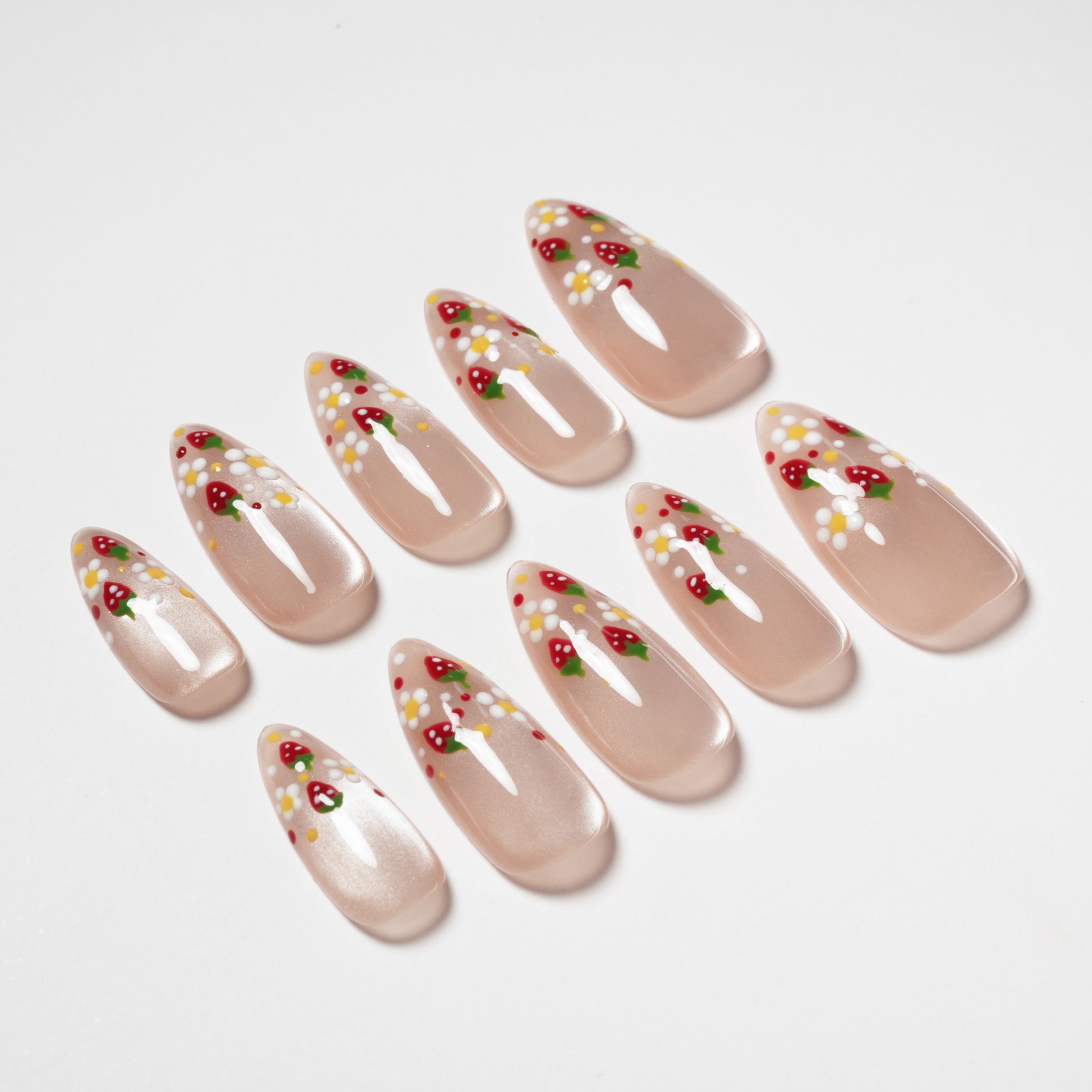 Handmade press-on nails with nude base, strawberry and daisy floral nail art design