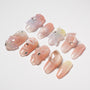 Handmade press-on nails with 3D floral and gem designs in pastel and pink hues