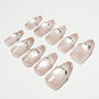 Glossy nude press-on nails with silver rhinestone accents arranged on a white background