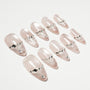 Glossy nude press-on nails with silver gem rhinestone accents, arranged on a white background