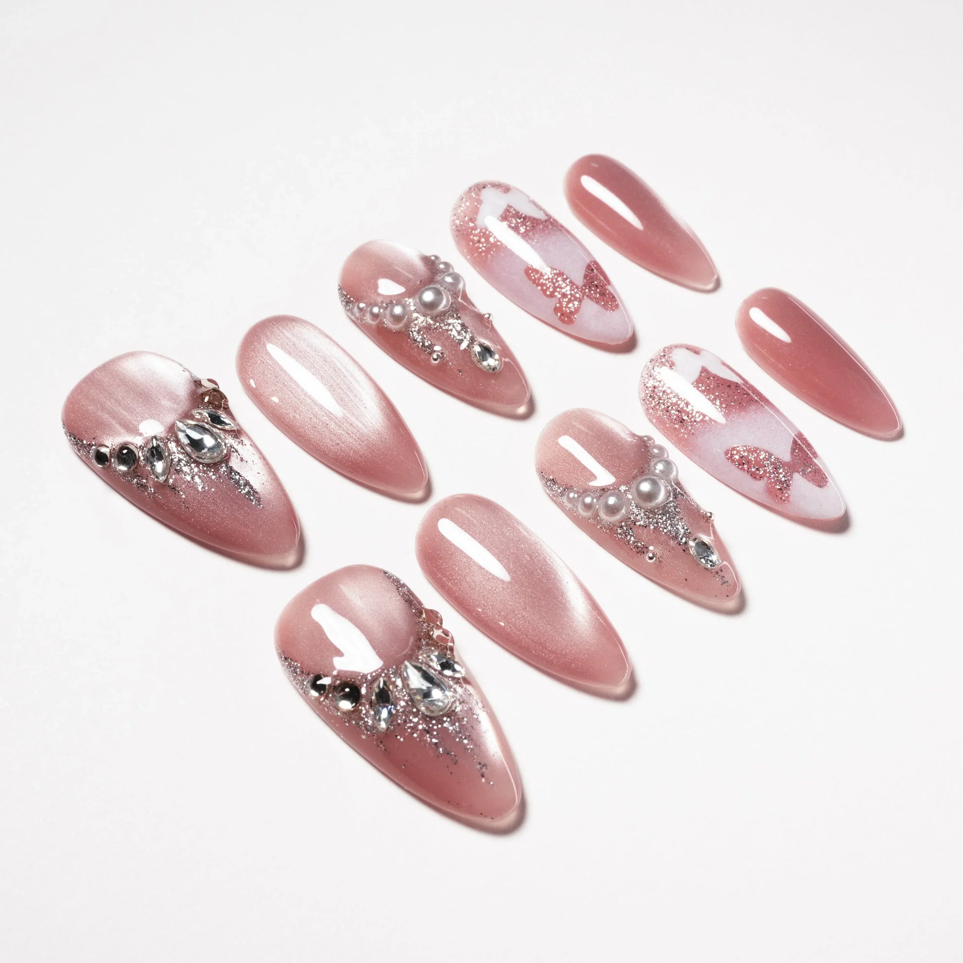Handmade pink press-on nails with pearls, rhinestones, and glitter butterfly designs
