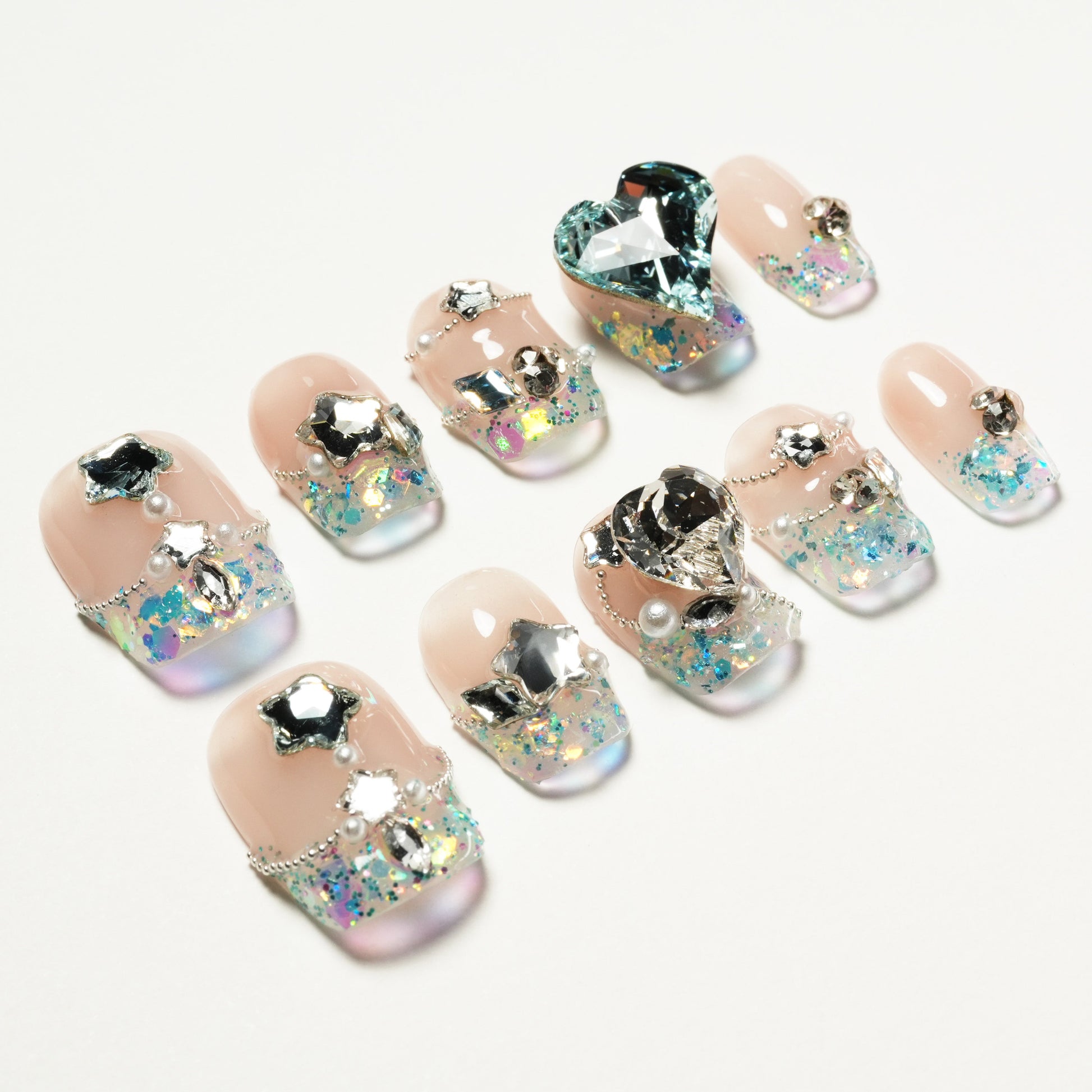 Handmade press-on nails with iridescent glitter, star gems, pearls, and heart rhinestone accents