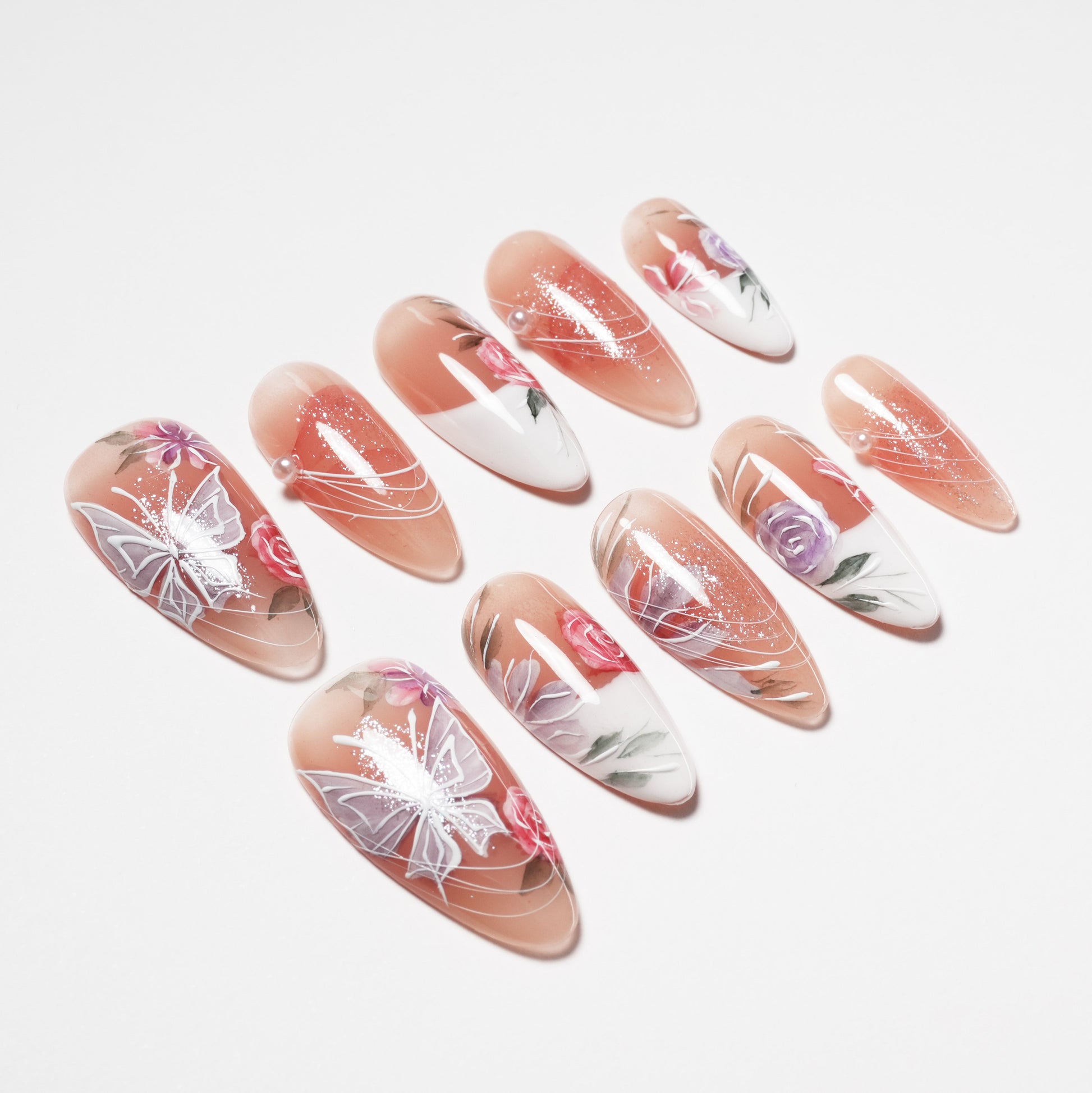 Handmade press-on nails with floral and butterfly design, nude and white base, glossy finish