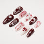 Set of red and white handmade press-on nails with heart, star, and bow designs, pearl accents