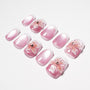Pink ombre press-on nails with white tips and 3D floral designs, glossy finish