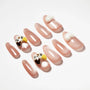 Handmade pink press-on nails with 3D cat face and paw designs, arranged on a white background