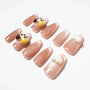 Glossy nude pink press-on nails with 3D cat and paw designs arranged on a white background.