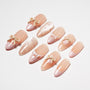 Handmade press-on nails in nude pink with 3D bows, polka dots, and French tip designs
