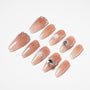 Handmade nude press-on nails with crystals, floral accents, and glitter on a white background