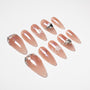 Long almond press-on nails in nude pink with glitter, white floral design, and rhinestone accents