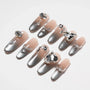 Gray and nude ombre press-on nails with rhinestone and gem embellishments on white background