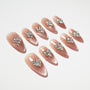 Almond-shaped nude press-on nails with rhinestone heart accents, glossy finish