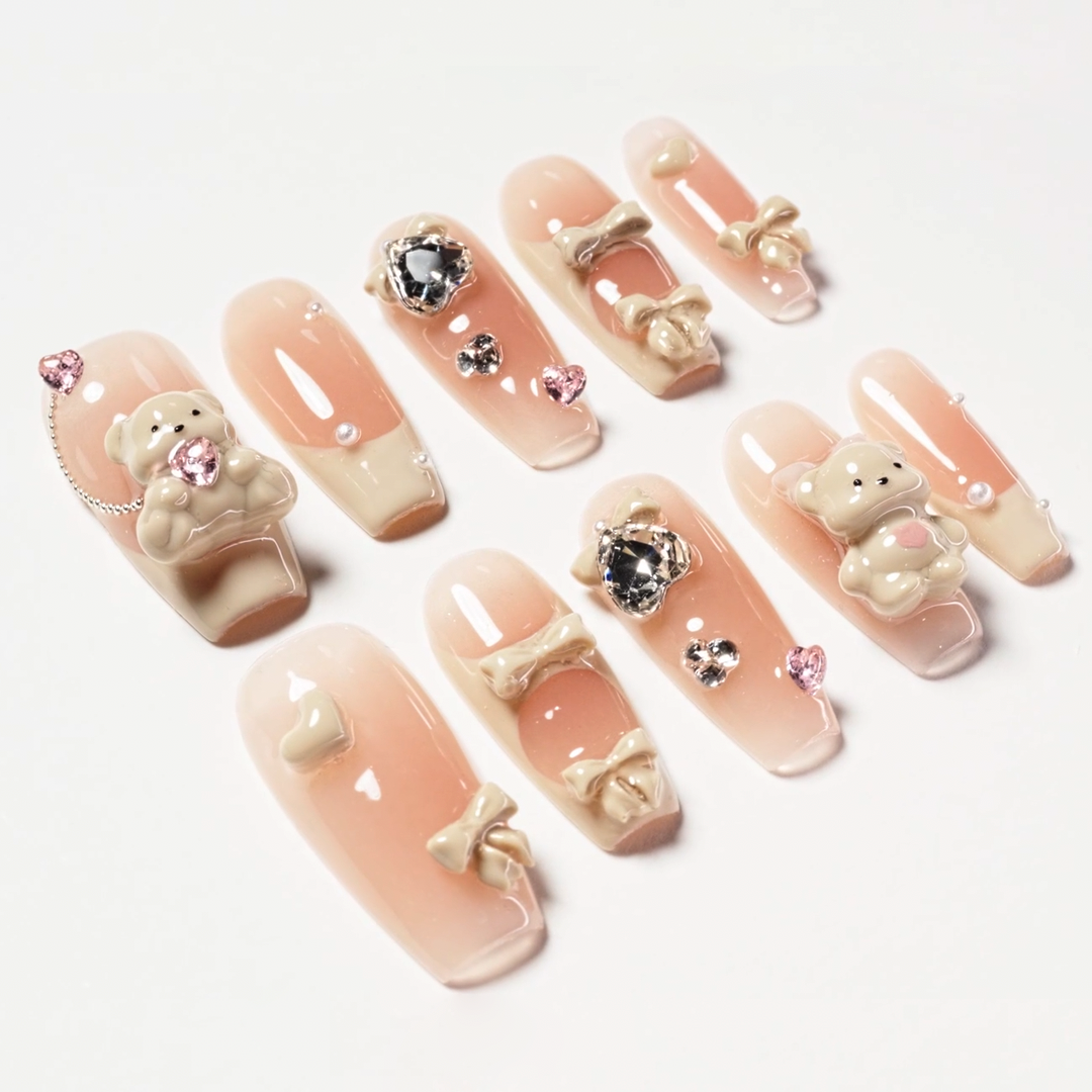 Cute press-on nails with 3D teddy bear, bows, pearls, and heart-shaped rhinestone accents