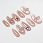 Handmade pink press-on nails with 3D bows and gemstone accents, displayed on white background