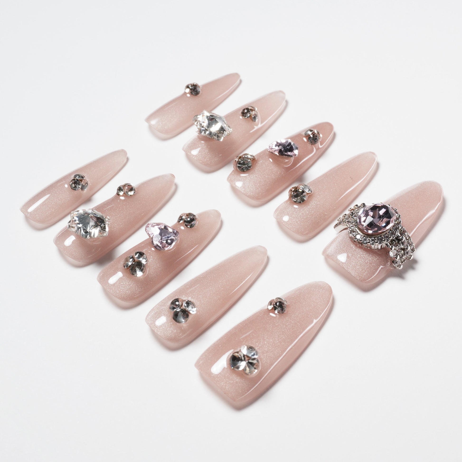 Long blush pink press-on nails with rhinestone and gem accents, elegant and sparkly design