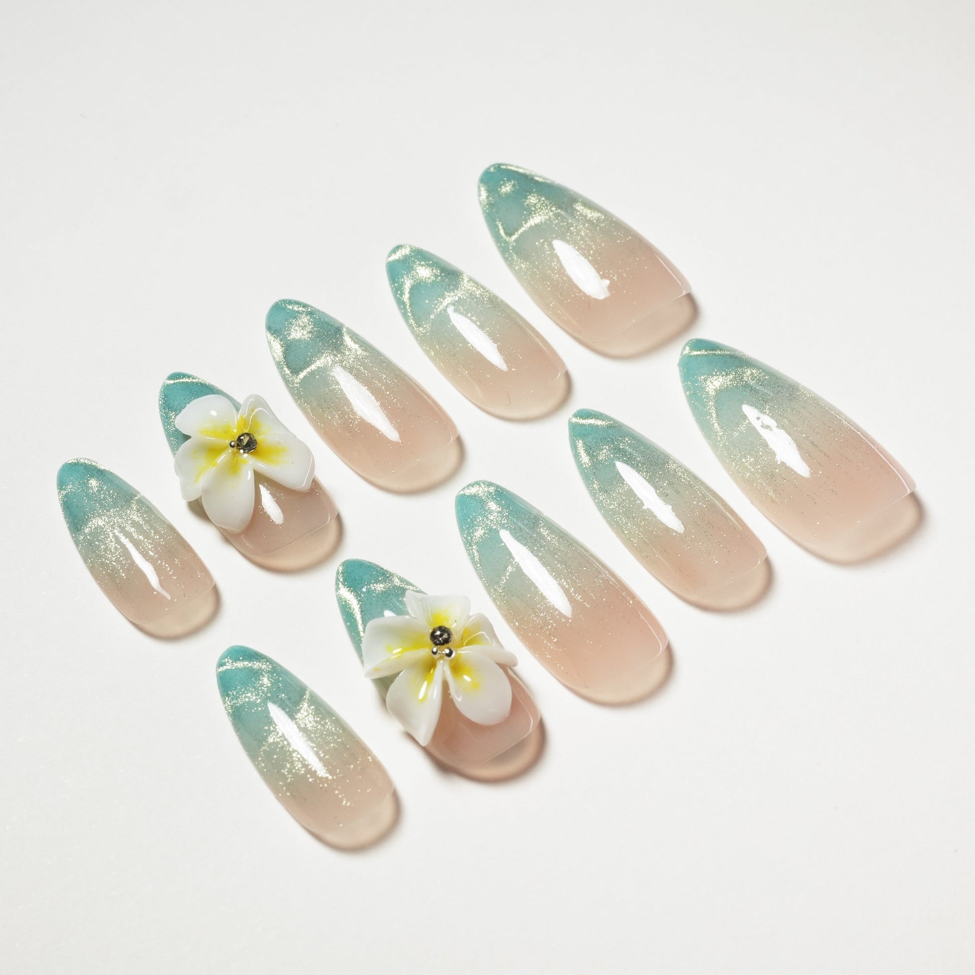 Handmade press-on nails in nude and teal ombre with glitter and 3D floral accents