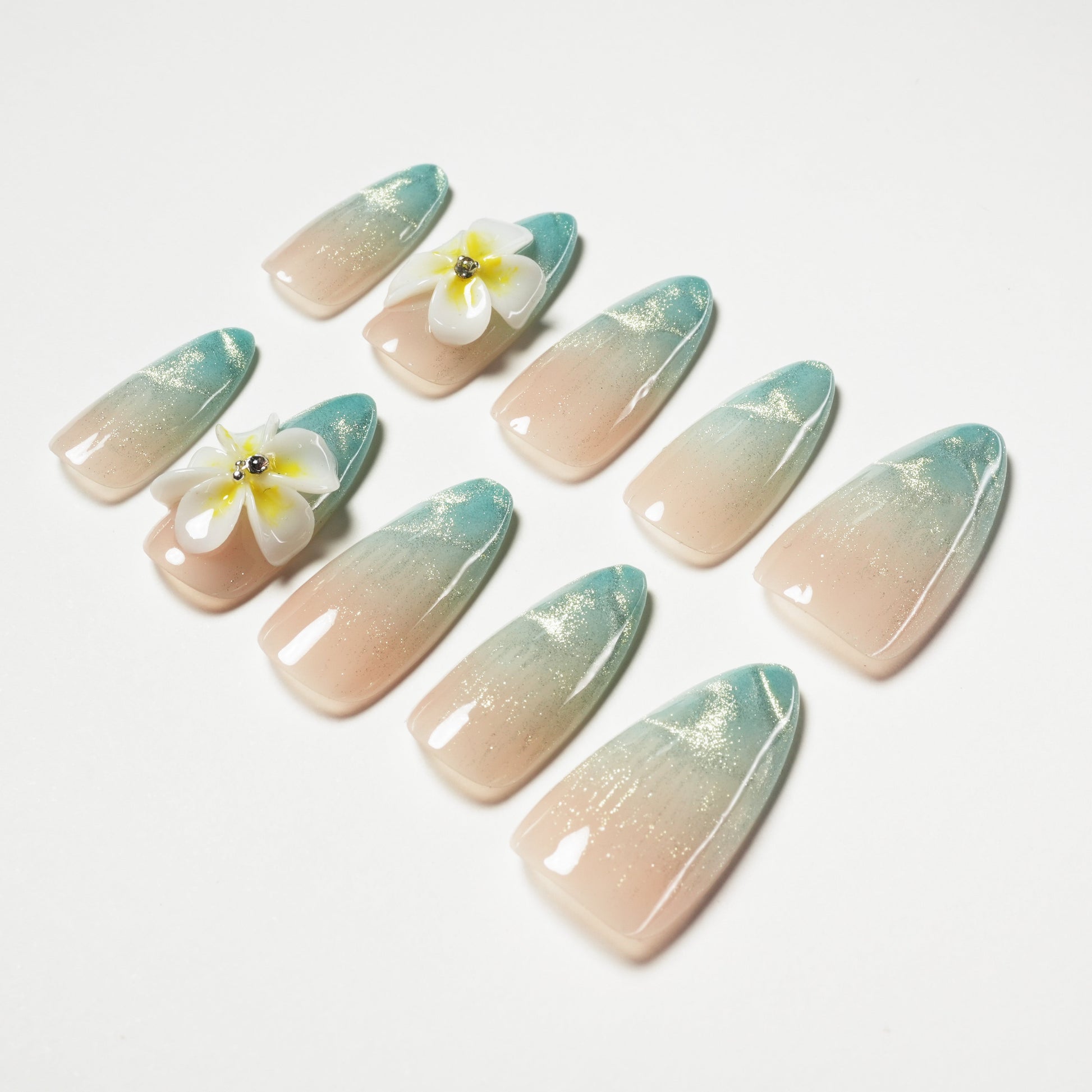 Handmade press-on nails in blue ombre with glitter and 3D floral accents