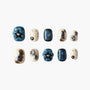 Blue and cream handmade press-on nails with 3D stars, metallic accents, and marbled designs.