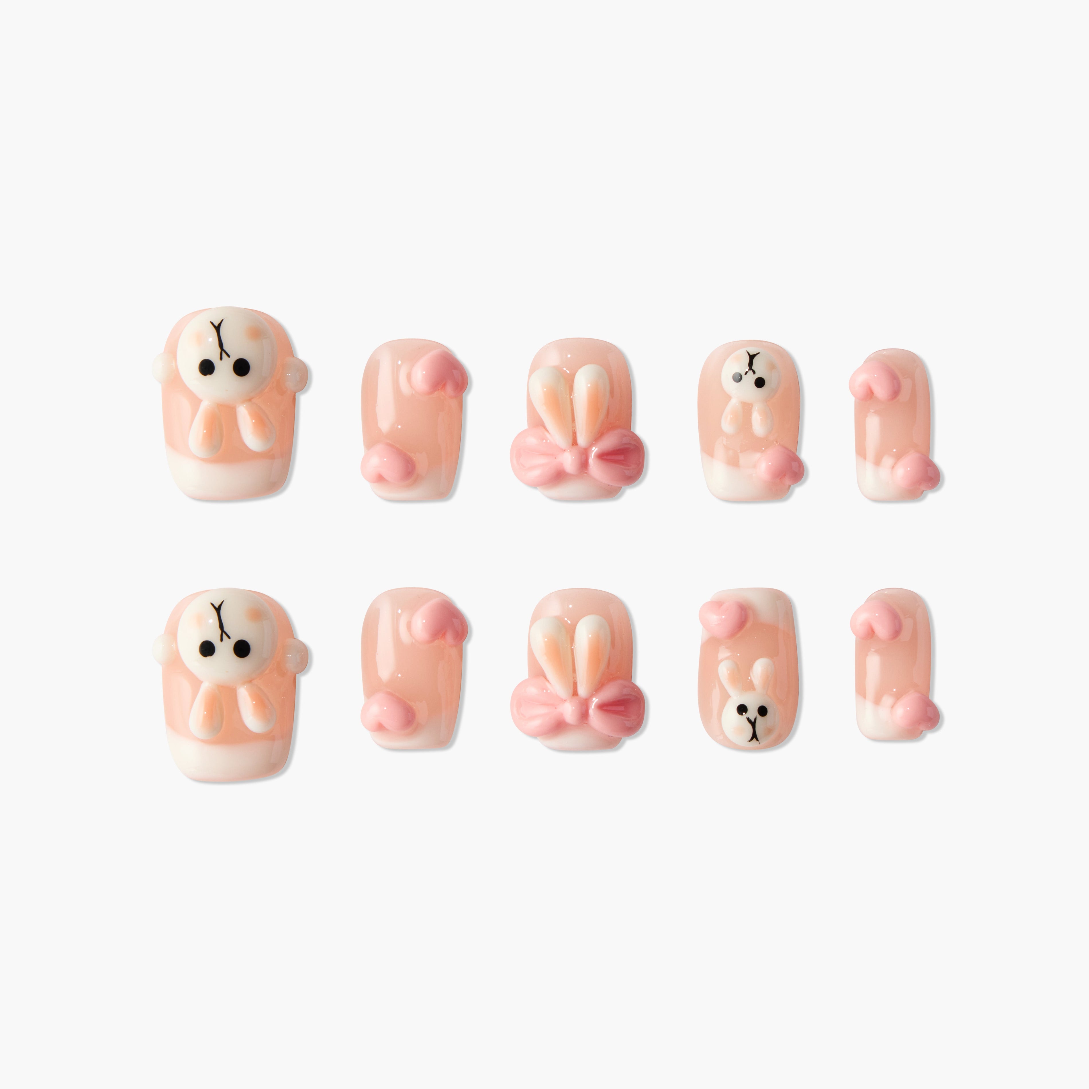 Handmade press-on nails with 3D pink bunny and heart designs on a nude base.