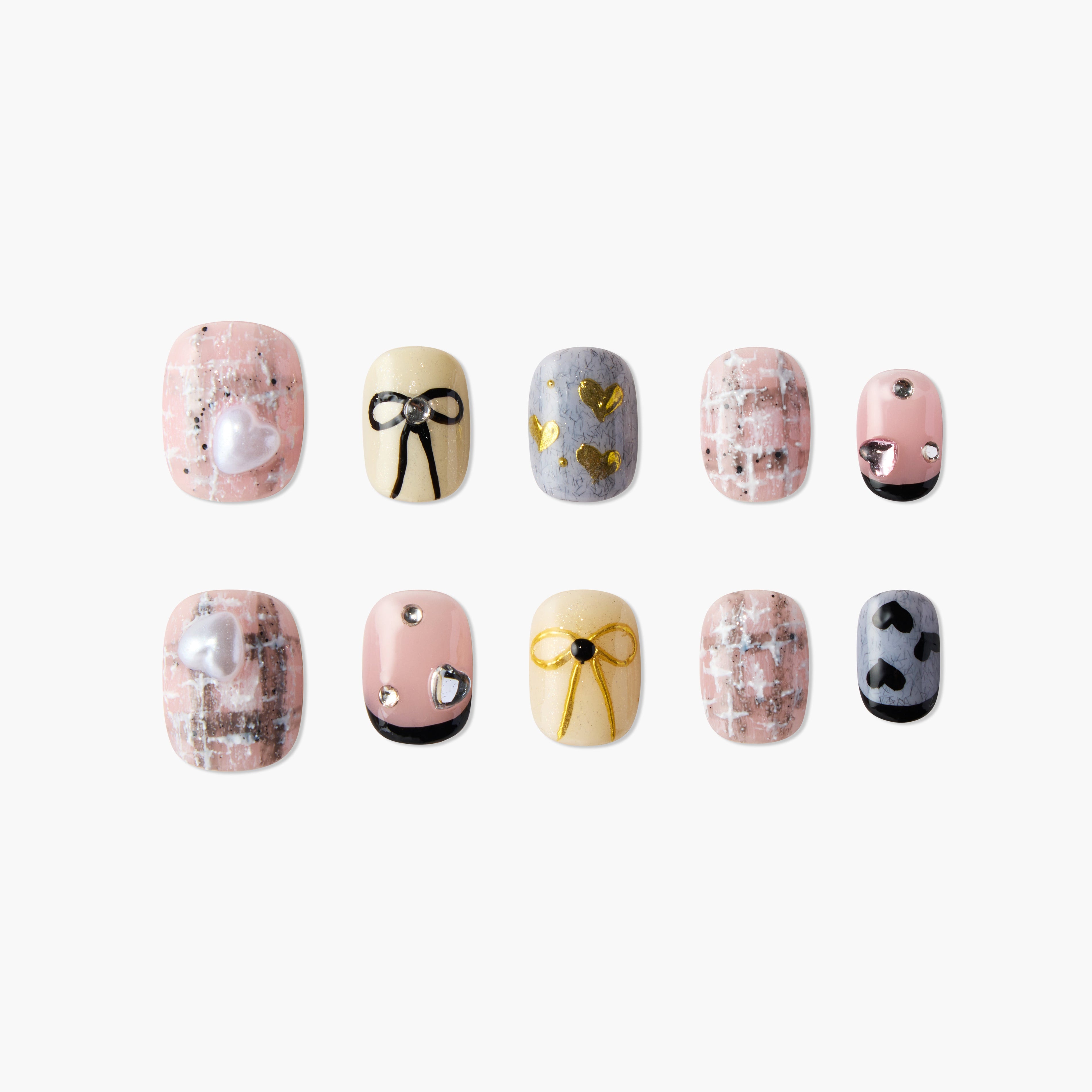Handmade press-on nails with pastel colors, bow, heart, and gem designs, displayed on white.