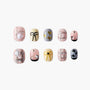 Handmade press-on nails with pastel colors, bow, heart, and gem designs, displayed on white.