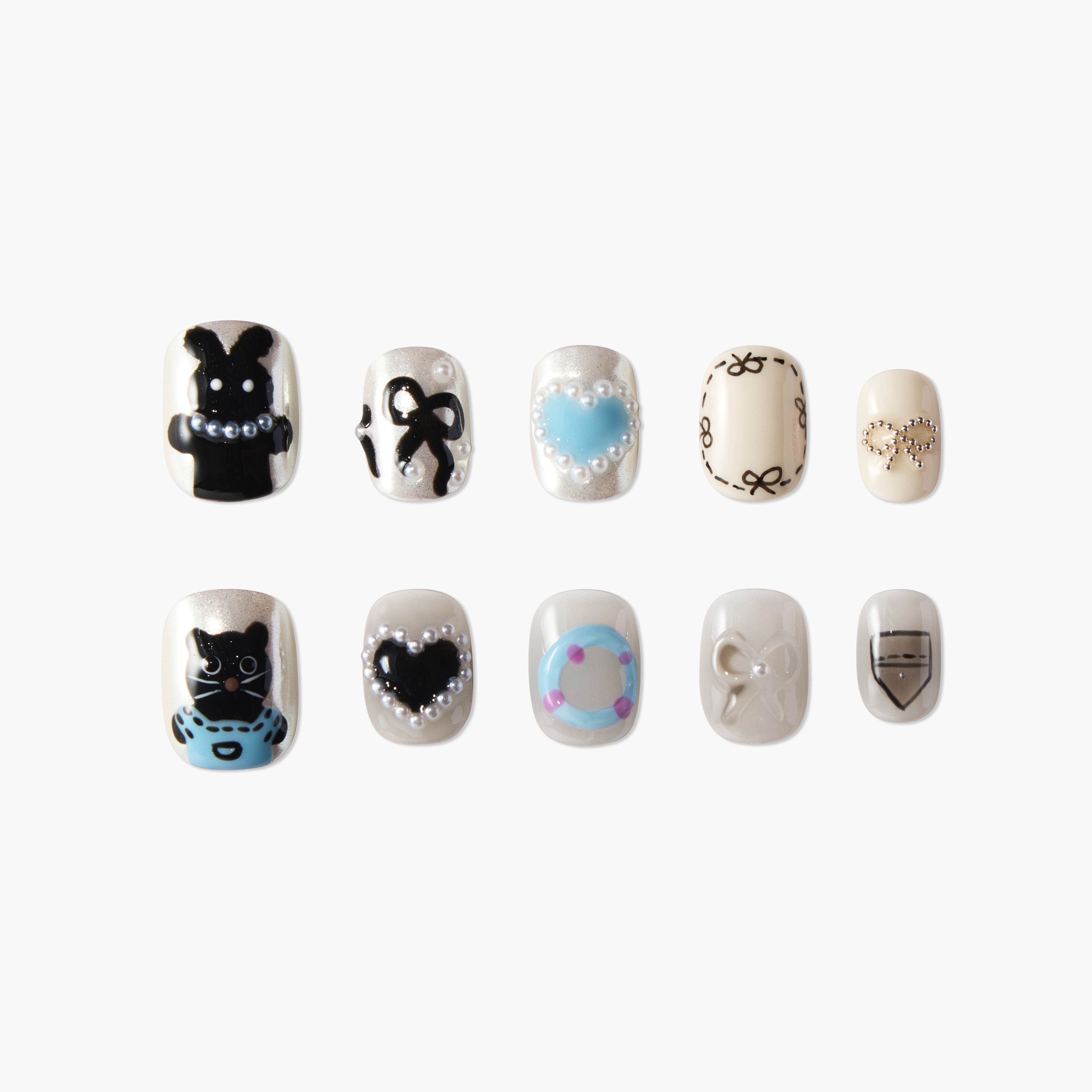 Handmade press-on nails with playful designs, featuring bears, hearts, bows, and pearl accents.
