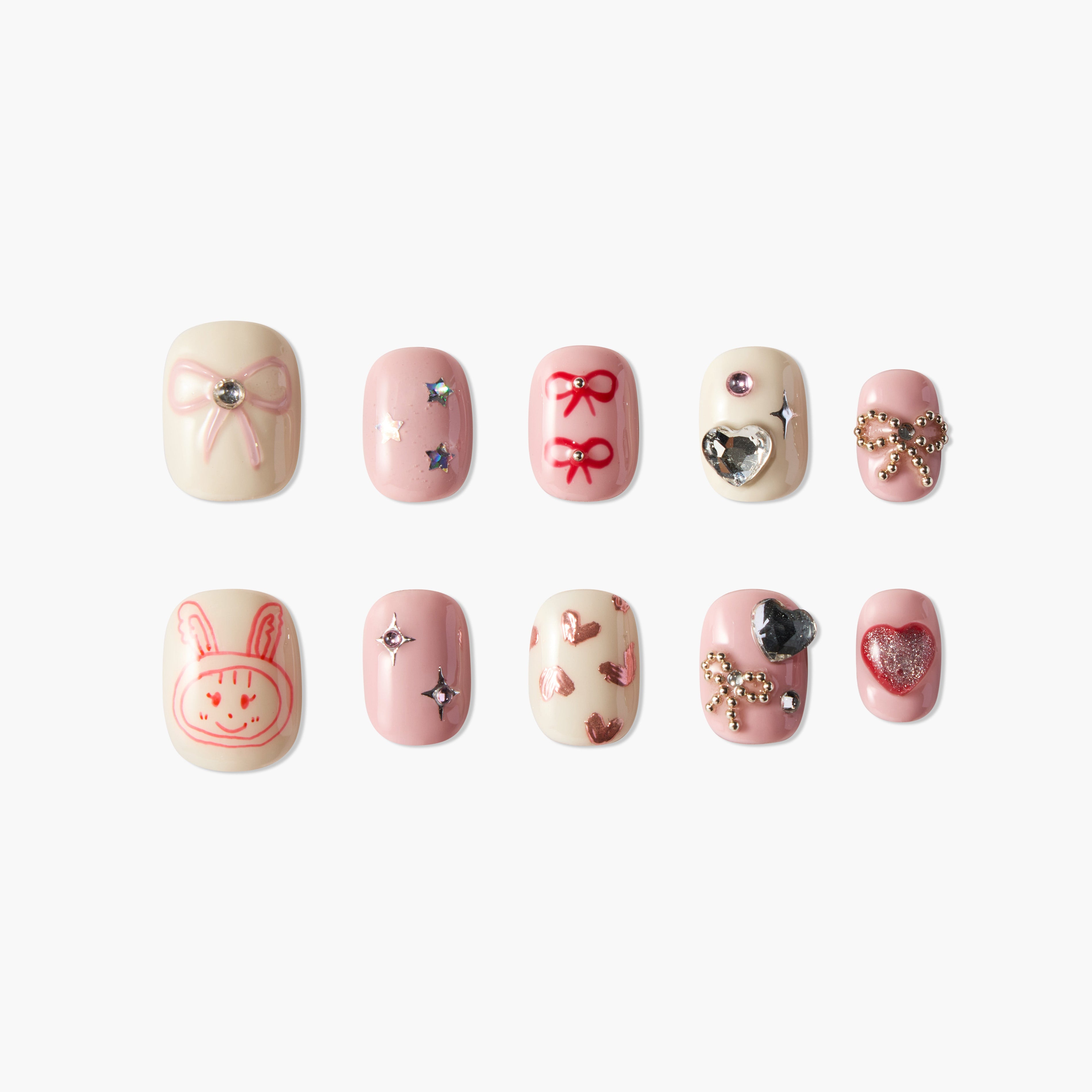 Handmade press-on nails with pink bows, hearts, gems, and cute bunny art on a white background