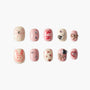 Handmade press-on nails with pink bows, hearts, gems, and cute bunny art on a white background