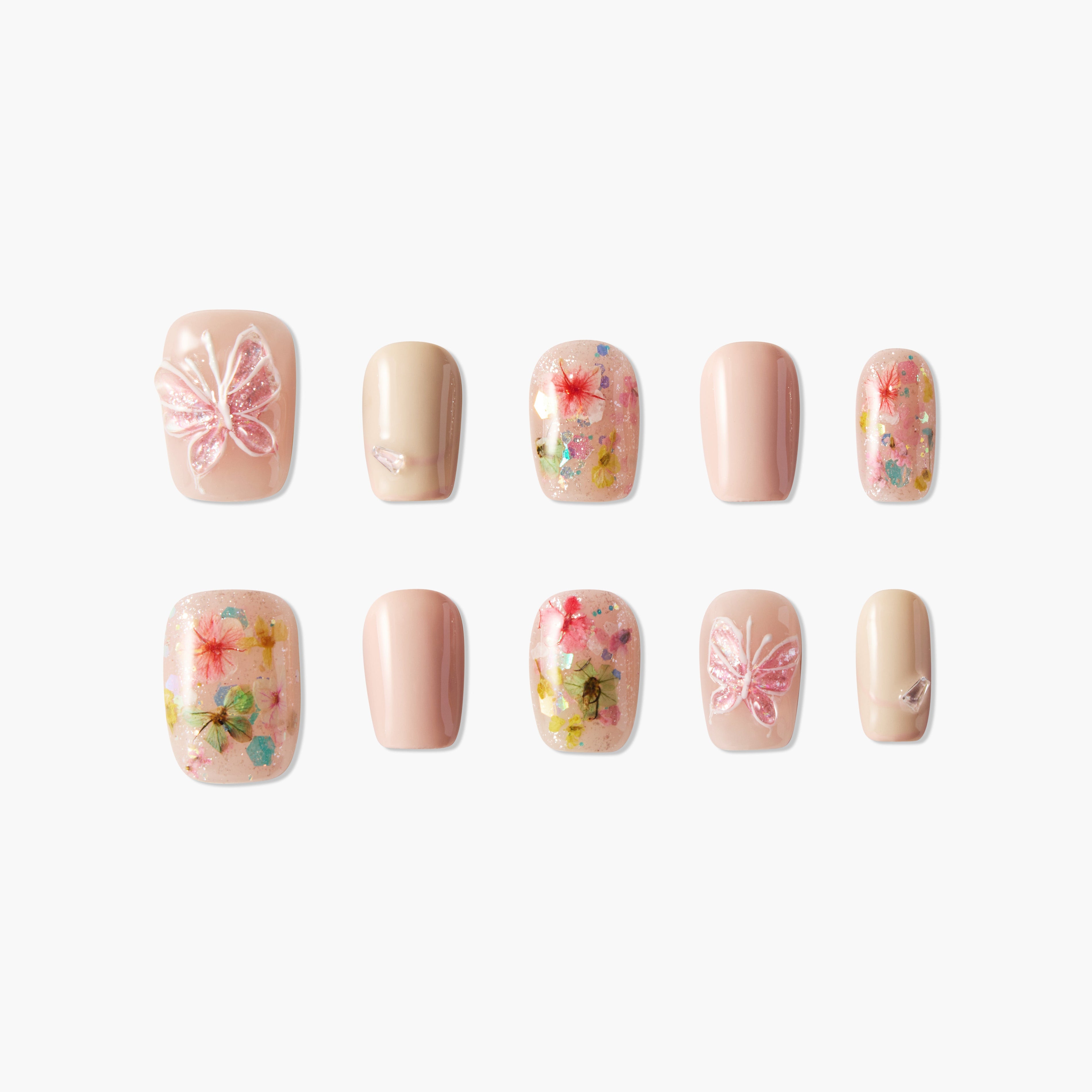Handmade press-on nails with pink butterfly and floral designs, glitter accents, nude tones