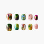 Handmade press-on nails with colorful marble and gold stud designs, arranged on white background.