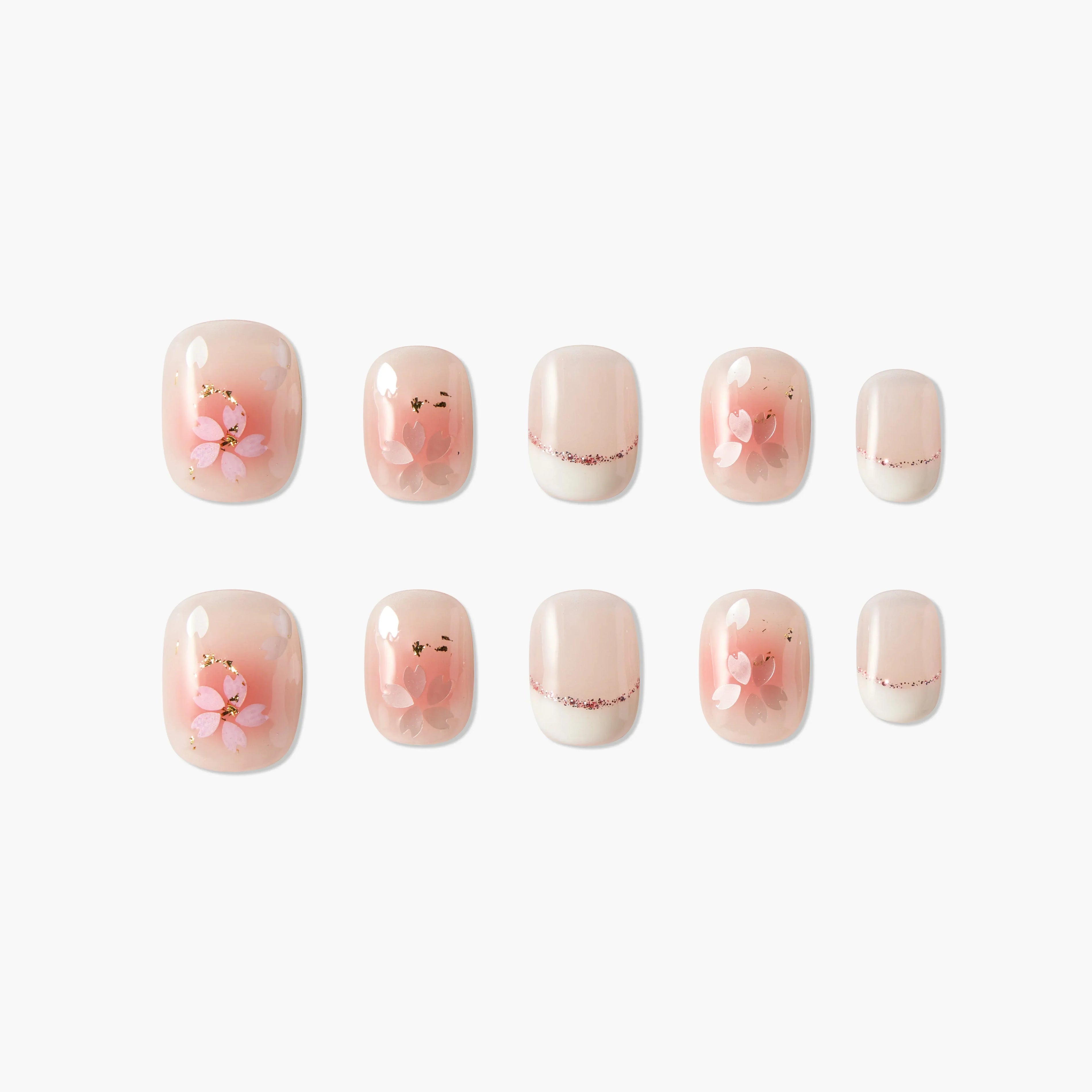 Handmade press-on nails with pink floral design and gold accents on a soft nude base