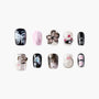 Handmade press-on nails with black, pink, and floral 3D designs on white background