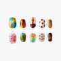 Handmade press-on nails with colorful, artistic designs including hearts, flowers, and patterns.