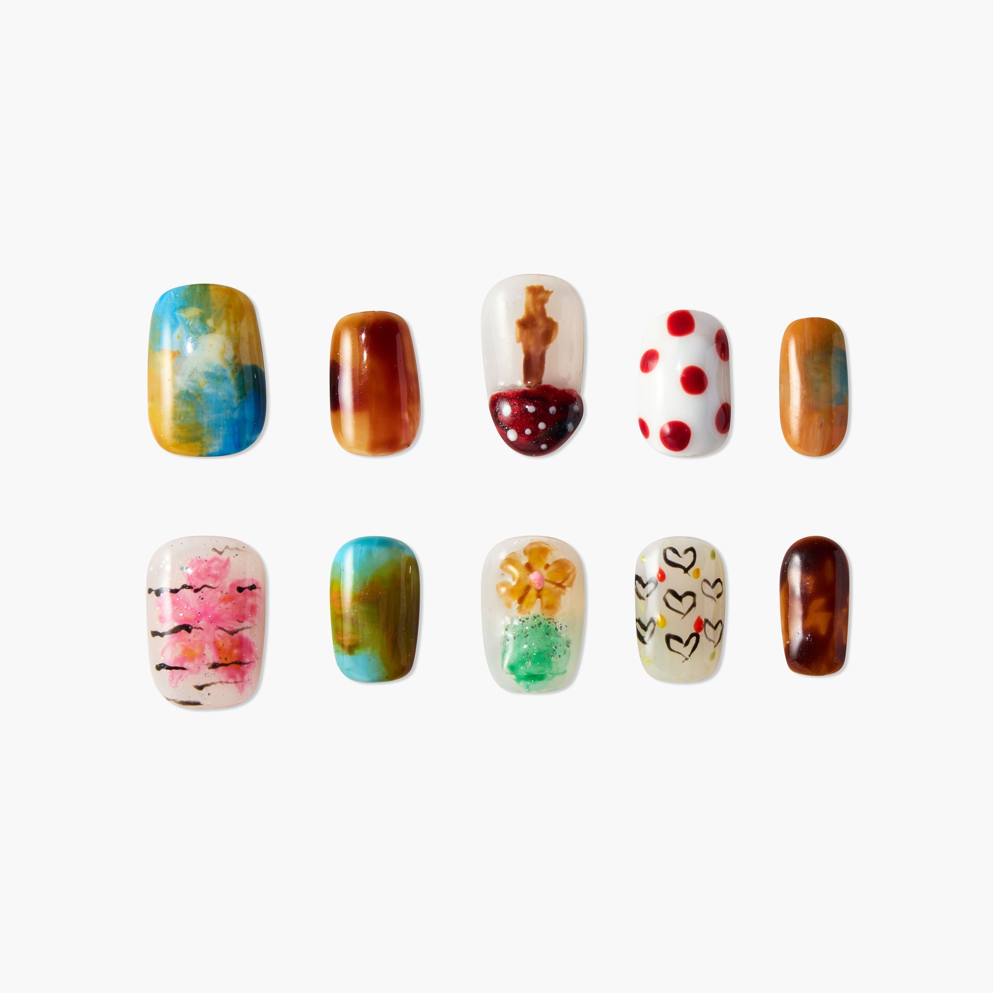 Handmade press-on nails with colorful, artistic designs including hearts, flowers, and patterns.
