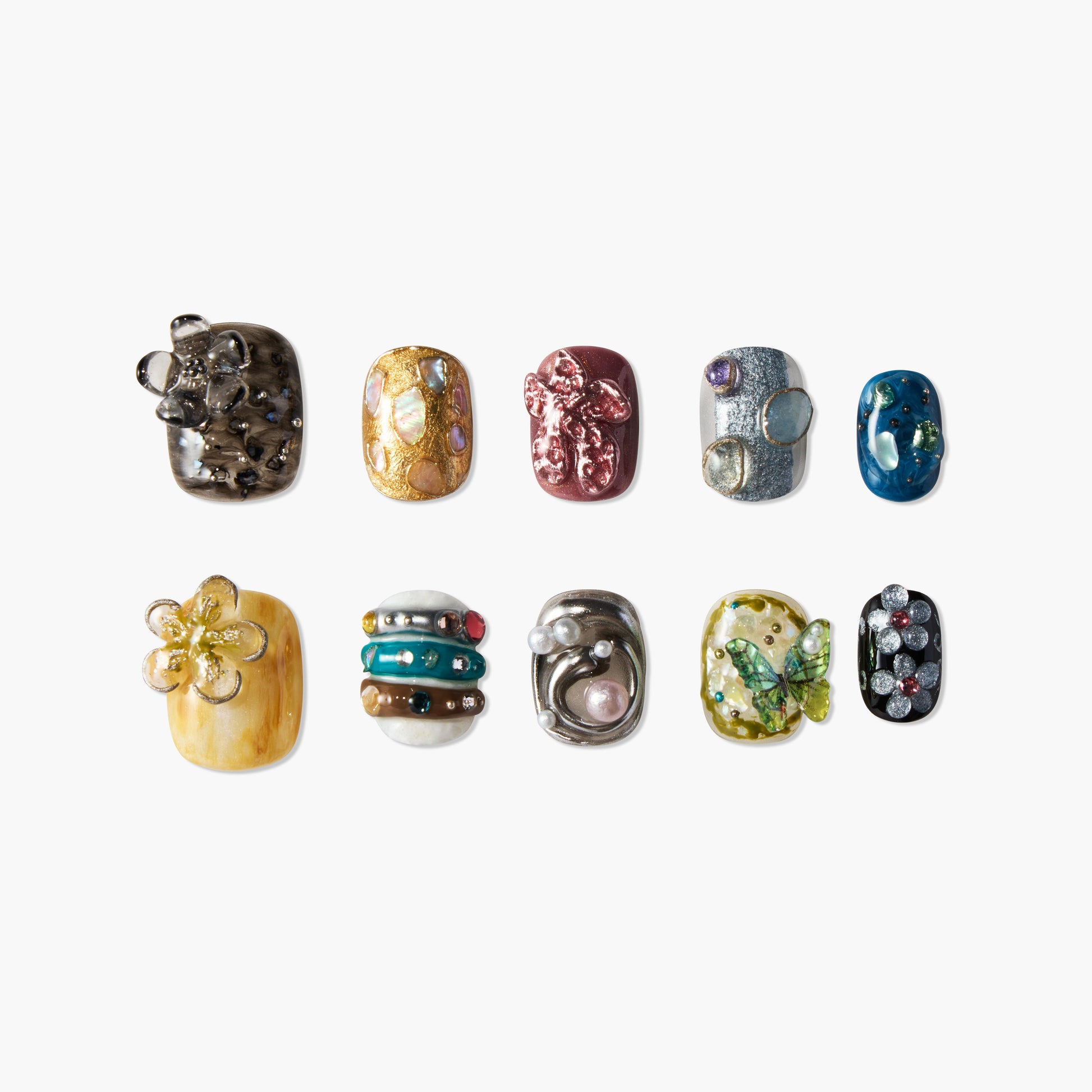 Handmade press-on nails with 3D floral, pearl, butterfly, and gem designs on various colors.