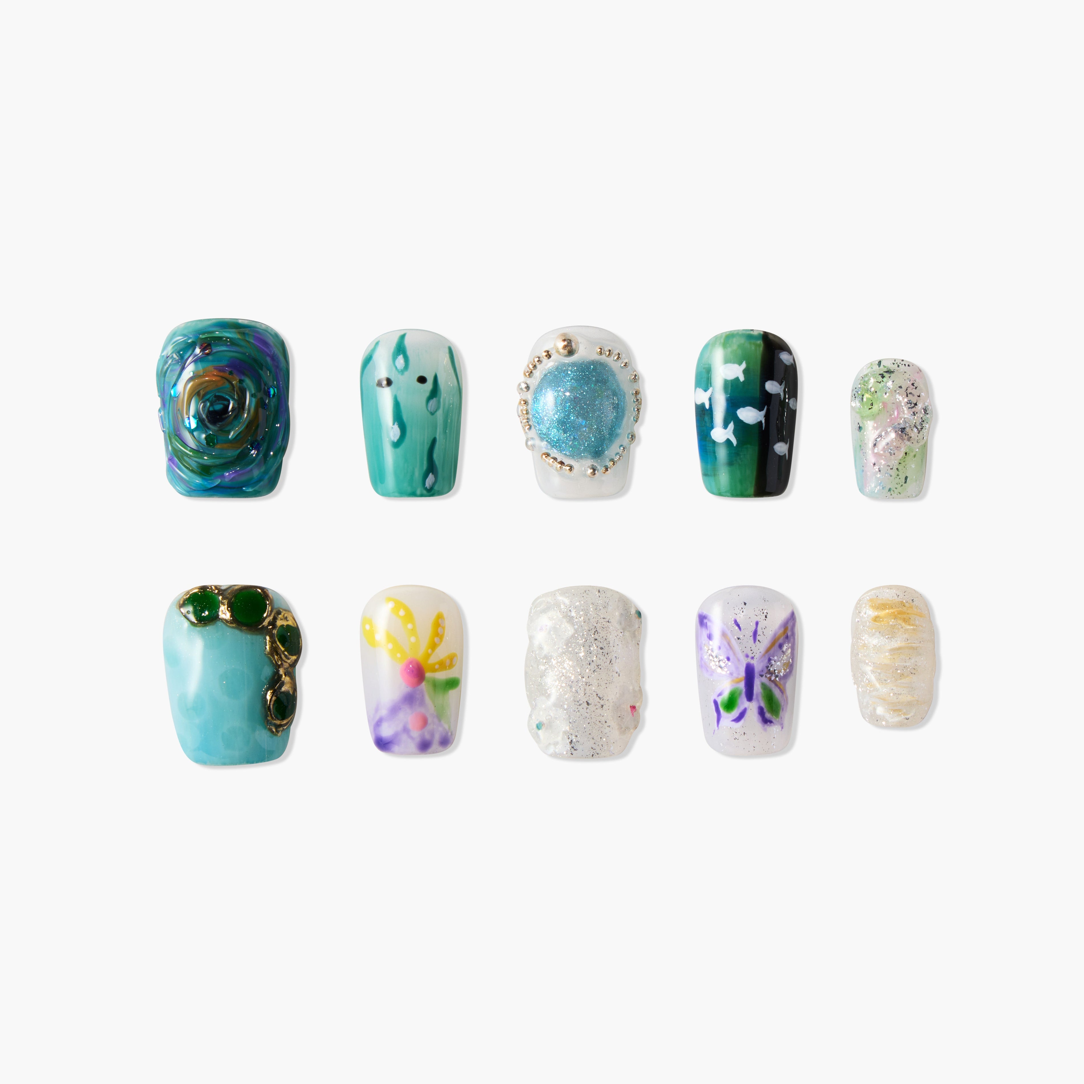 Assorted handmade press-on nails with blue, green, floral, butterfly, and glitter designs