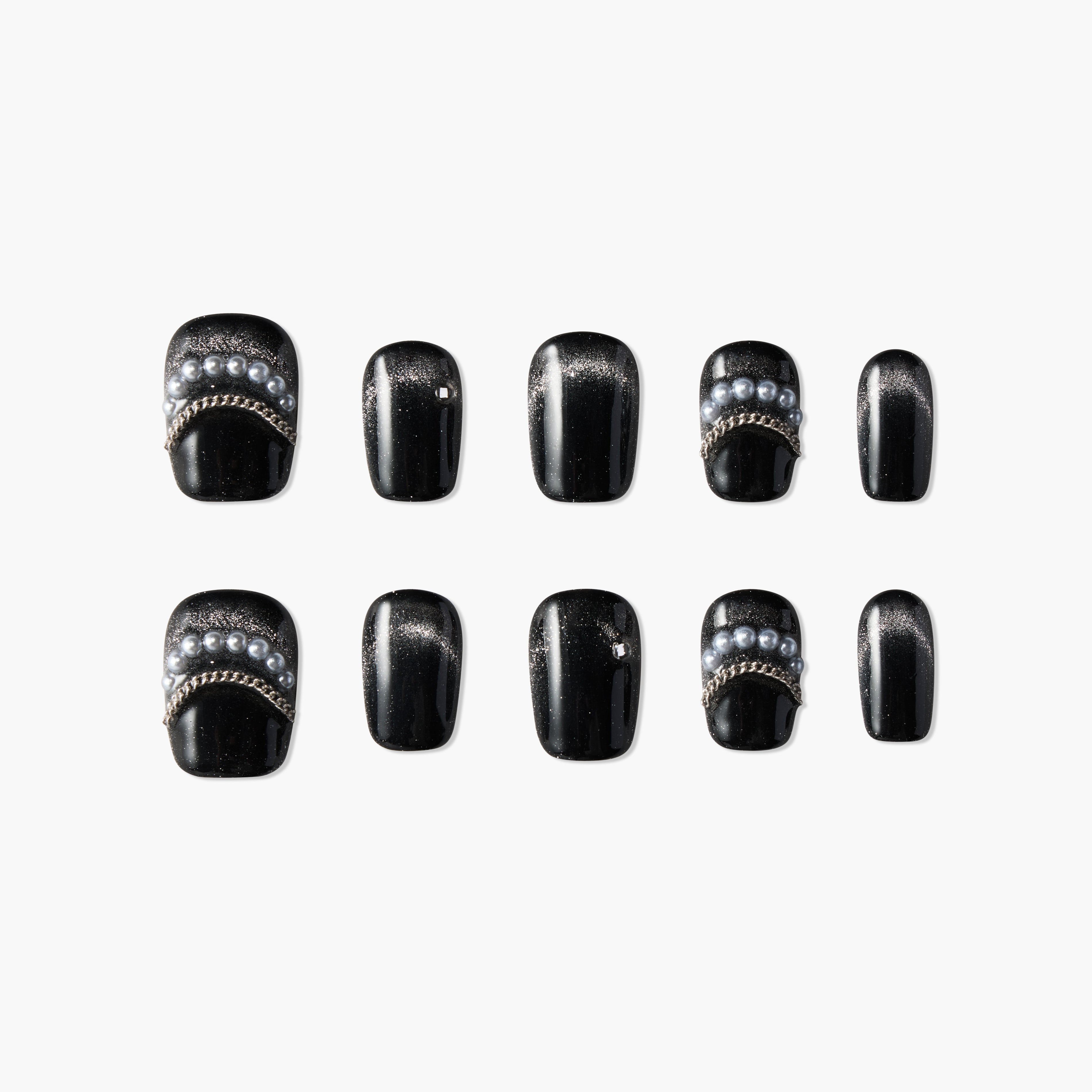 Black press-on nails with pearl and chain accents, arranged on a white background.