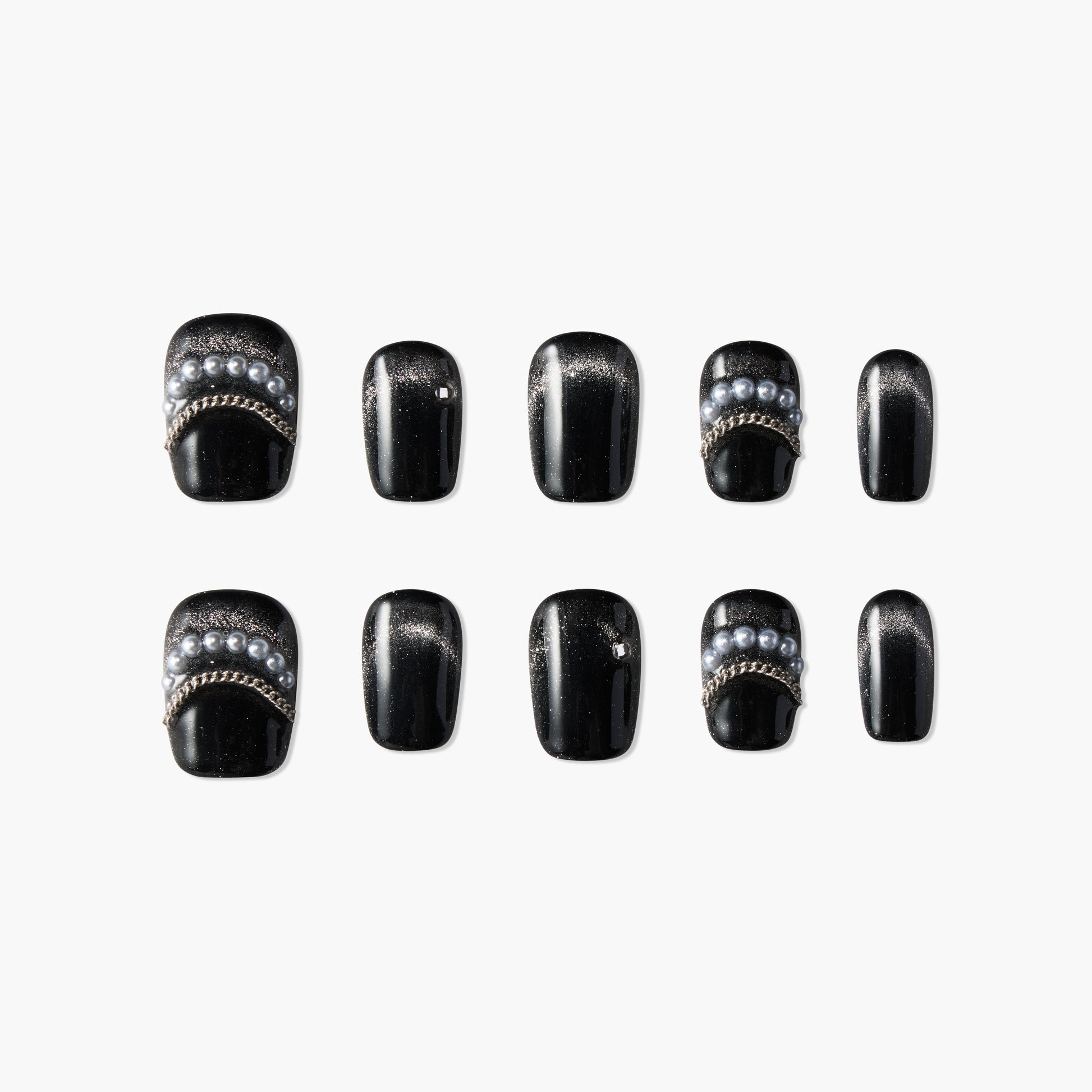Black press-on nails with pearl and chain accents, arranged on a white background.