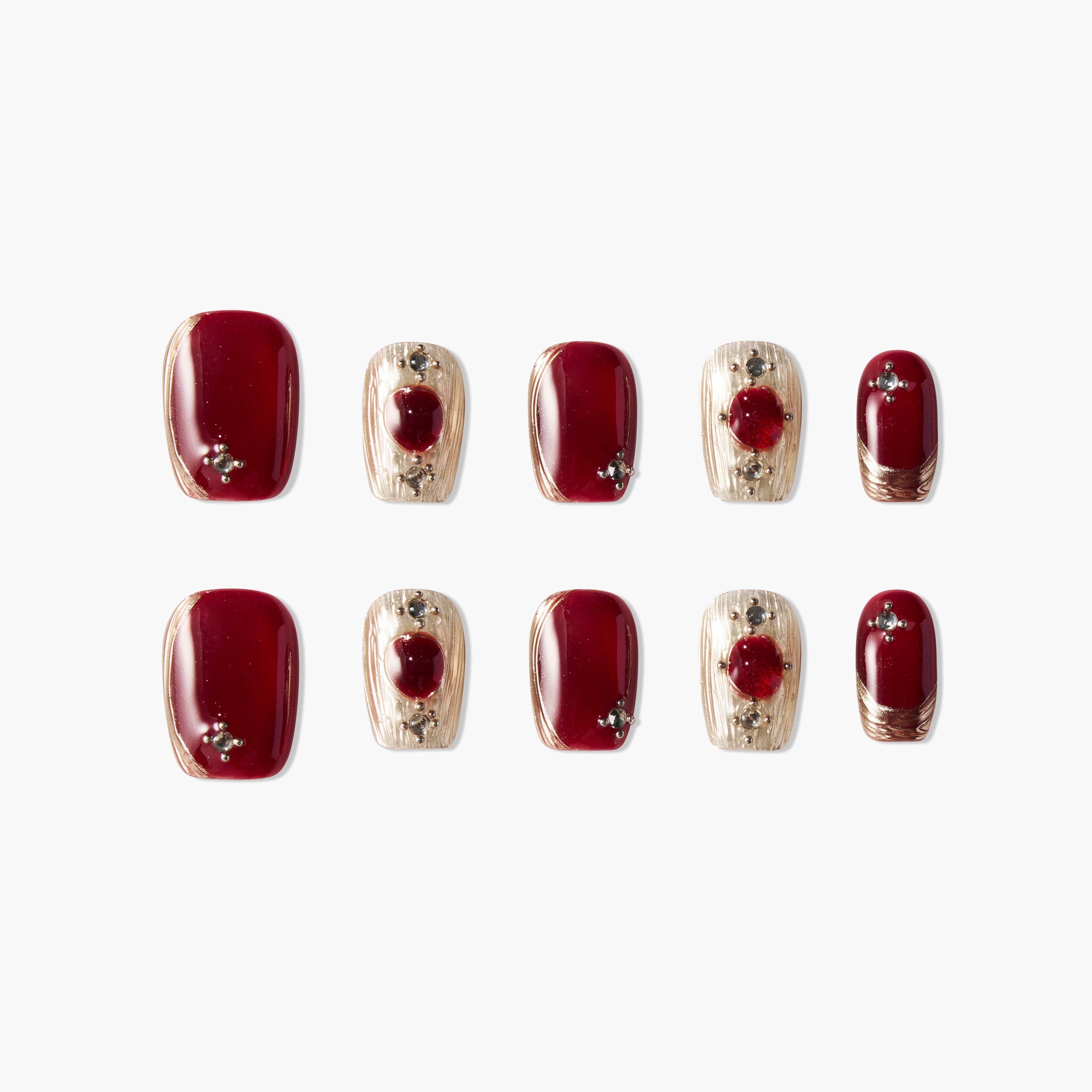 Handmade press-on nails set with glossy burgundy and gold designs, jewel accents, and almond shape