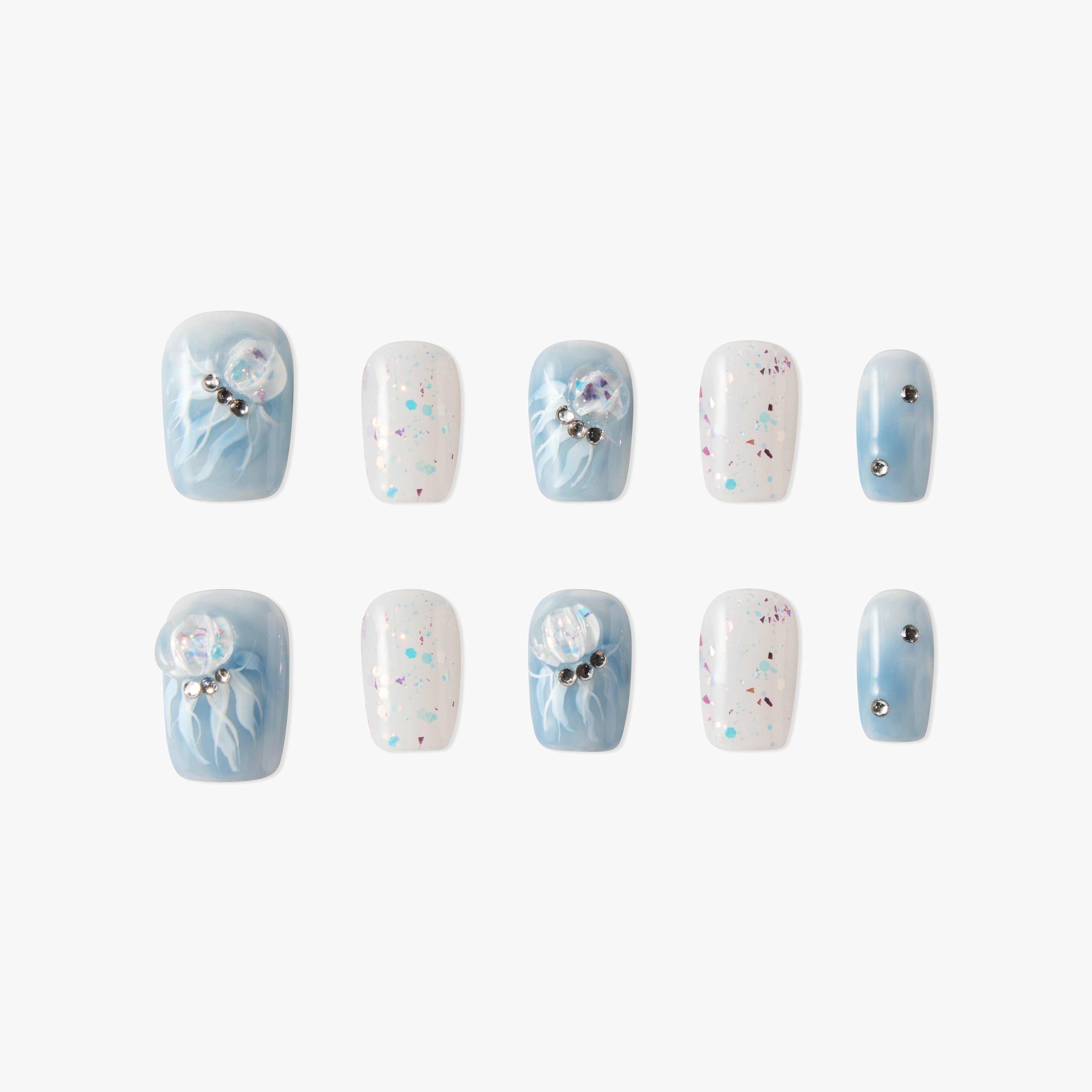 Blue and white press-on nails with jellyfish designs, glitter, and rhinestone accents