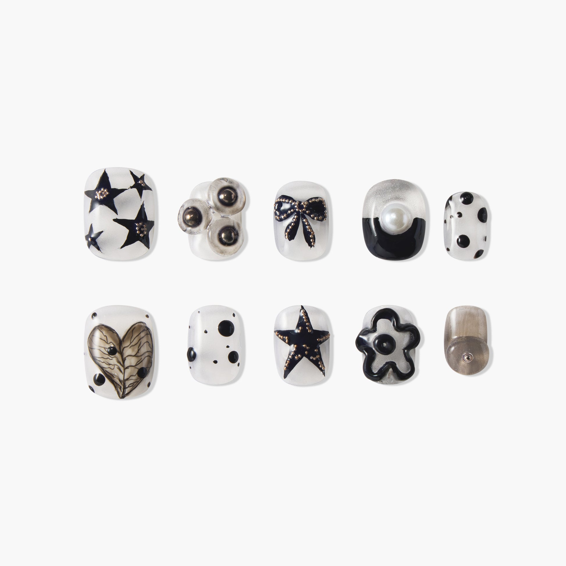 Handmade press-on nails with black star, heart, bow, pearl, polka dot, and flower designs