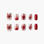 Red and white press-on nails with butterfly, rose, glitter, ombre, and solid designs.