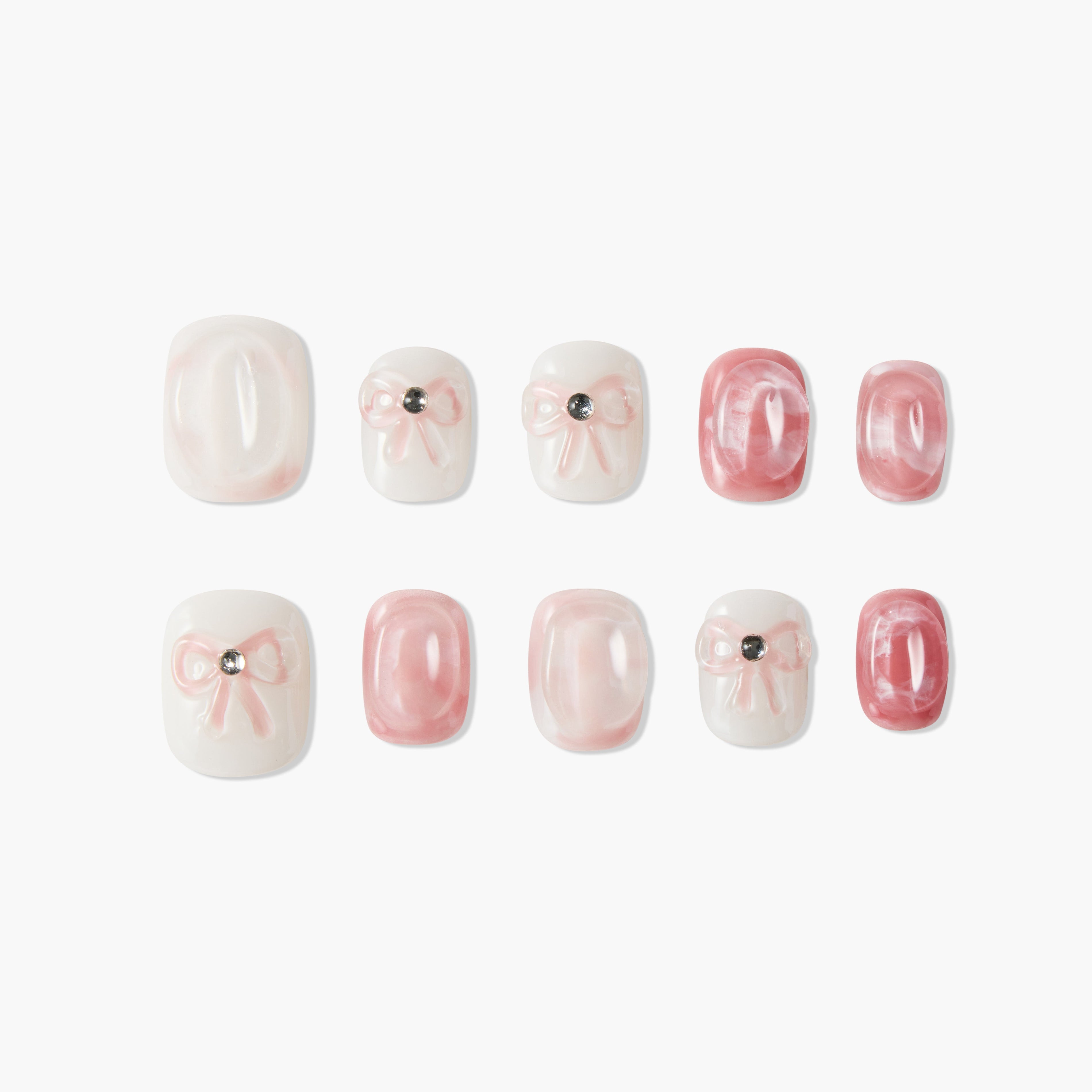 Pink and white press-on nails with bow and gem accents, glossy marble effect, reusable manicure