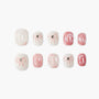 Pink and white press-on nails with bow and gem accents, glossy marble effect, reusable manicure