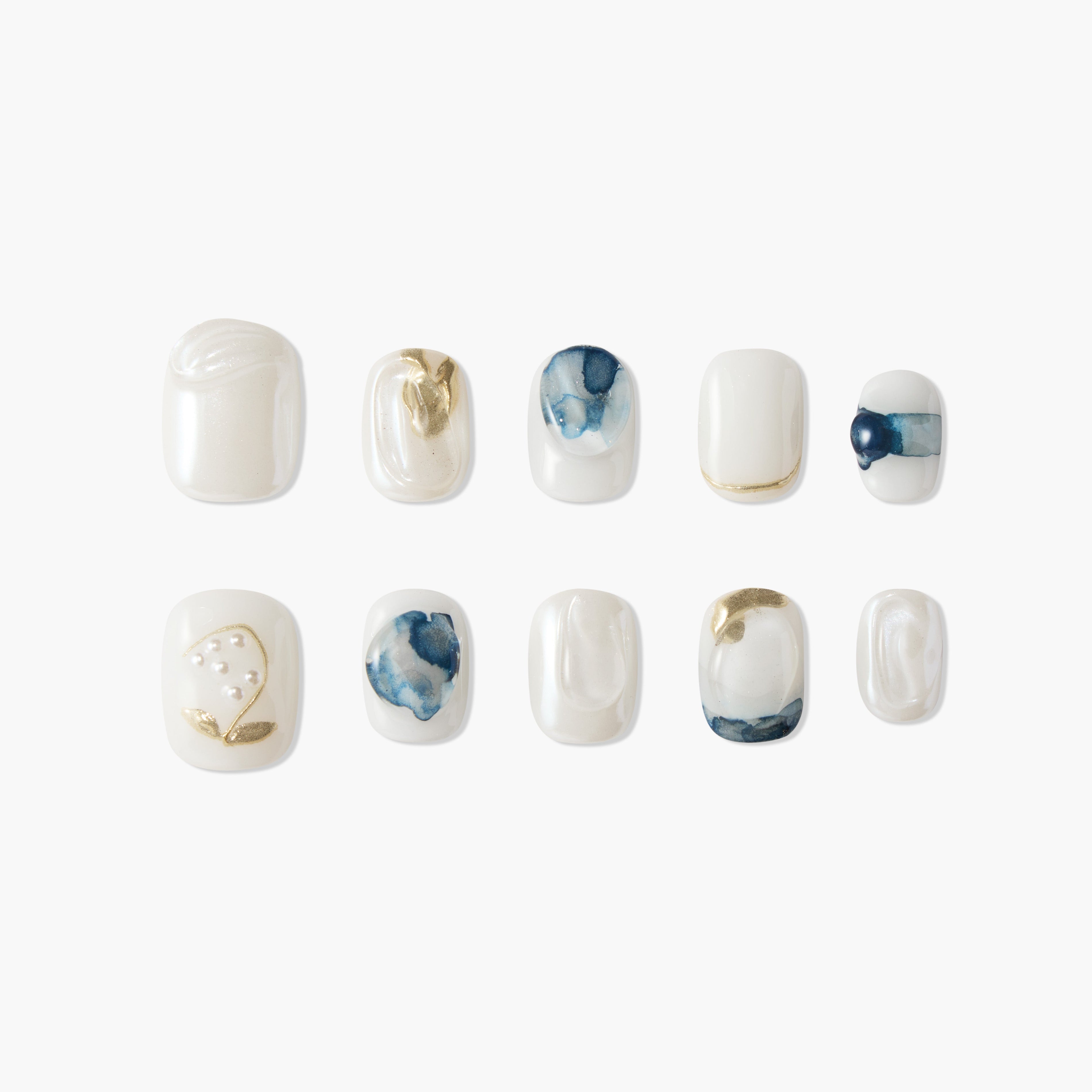 Handmade press-on nails with white, gold, and blue marble and pearl accents, arranged on white background