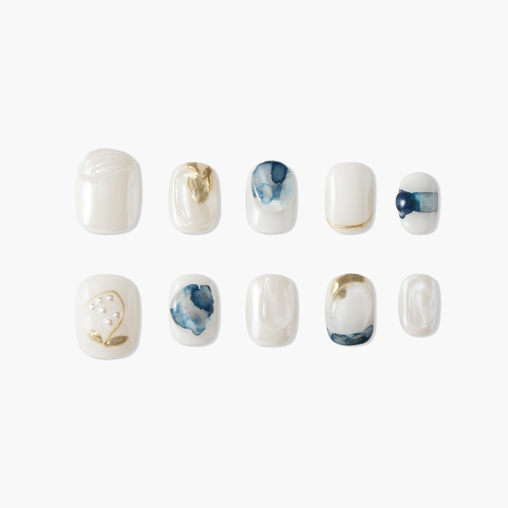 Handmade press-on nails with white, gold, and blue marble and pearl accents, arranged on white background