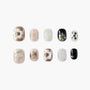 Set of handmade press-on nails with metallic, glitter, floral, and star designs on a white background