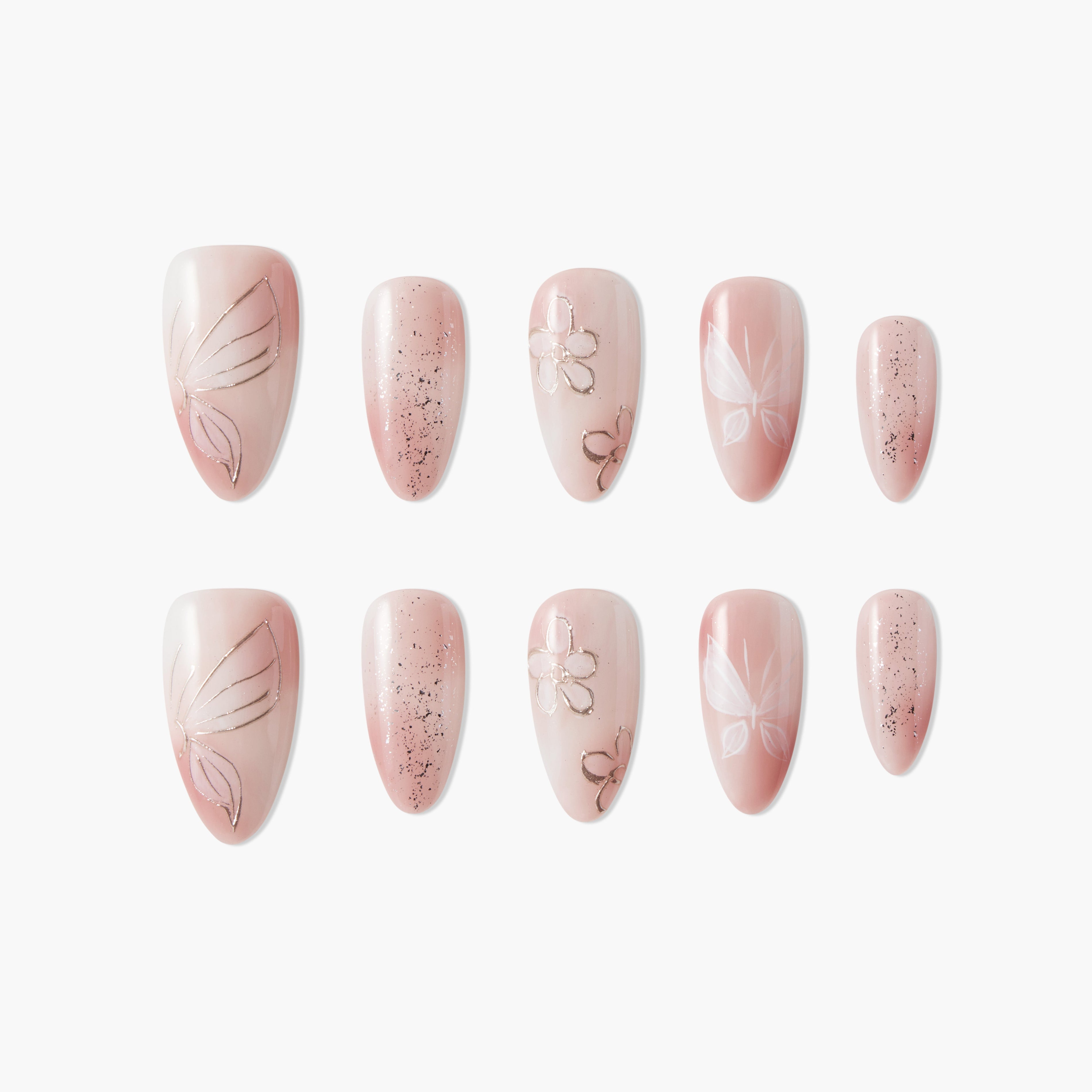 Handmade press-on nails in blush pink with butterfly, floral, and glitter designs, arranged on white background.